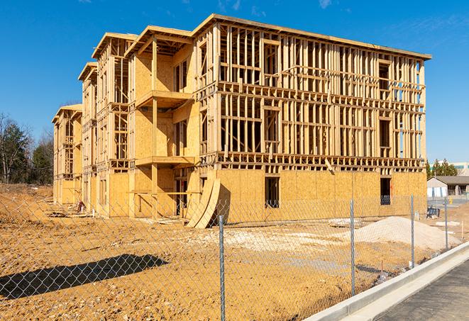 a temporary chain link fence in front of a building under construction, ensuring public safety in Rogers, TX